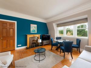 een woonkamer met een tafel en een open haard bij Rosebery Place in Gullane
