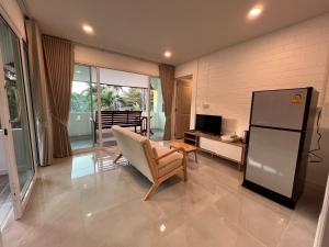 a living room with a chair and a refrigerator at Naisang Hostel in Chumphon