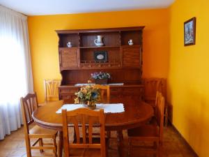 a dining room with a wooden table and chairs at Casa Quini in Biescas +7 photos