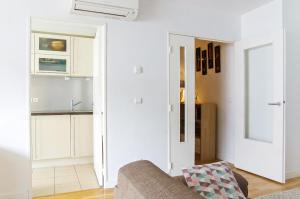 een woonkamer met een bank en een keuken bij Belfort - Appartement 2 chambres avec ascenseur et Parking in Bordeaux