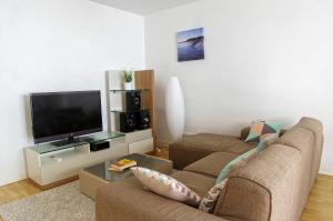 a living room with two couches and a flat screen tv at Belfort - Appartement 2 chambres avec ascenseur et Parking in Bordeaux