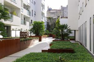 a courtyard in a building with trees and plants at Belfort - Appartement 2 chambres avec ascenseur et Parking in Bordeaux