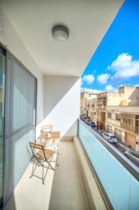 balcón con mesa, sillas y vistas a la ciudad en Large and modern 2bedroom with balcony GLUB1-1, en Il-Gżira