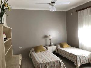 um quarto com 2 camas e uma ventoinha de tecto em Piedra Rosada em Santiago del Estero