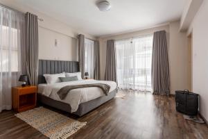 a bedroom with a large bed and large windows at Mizuki in Nairobi +30 photos