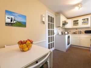 a kitchen with a bowl of fruit on a table at Southcot in North Berwick +10 photos