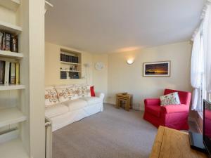 a living room with a white couch and a red chair at Southcot in North Berwick