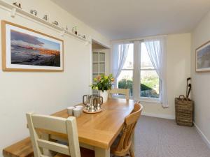 a dining room with a wooden table and a large window at Southcot in North Berwick
