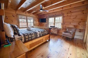 a bedroom in a log cabin with a bed and a desk at Bucking Bison - Pet friendly, mountain view, hot tub, game room, fire pit and more! in Mineral Bluff