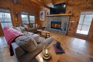 a living room with a couch and a fireplace at Bucking Bison - Pet friendly, mountain view, hot tub, game room, fire pit and more! in Mineral Bluff