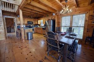 a kitchen with a table and chairs in a cabin at Bucking Bison - Pet friendly, mountain view, hot tub, game room, fire pit and more! in Mineral Bluff