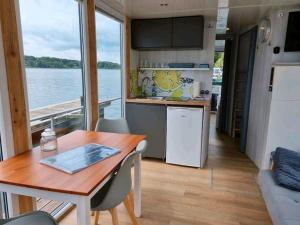 a kitchen and dining room with a table in a boat at Hausboot STEHEND Grey Pearl in Fürstenberg