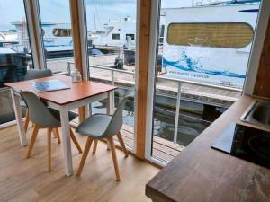 a table and chairs in a room with a window at Hausboot STEHEND Grey Pearl in Fürstenberg +7 photos