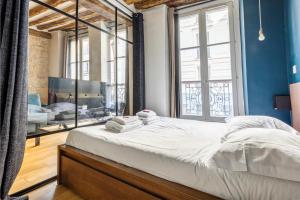 a bedroom with a large bed with blue walls at CMG République / Montorgueil __ Nazareth G in Paris