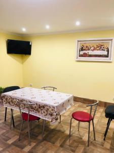 a table in a room with chairs and a painting on the wall at Катерина in Chynadiyovo
