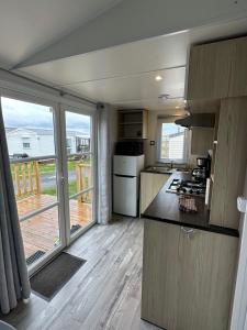 a kitchen with a stove and a large window at La côte sauvage - MH climatisé 2018 - P30 - Le Portel in Le Portel