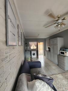 - un salon avec un canapé et un ventilateur de plafond dans l'établissement Apartment at Kitchener, à Middelburg