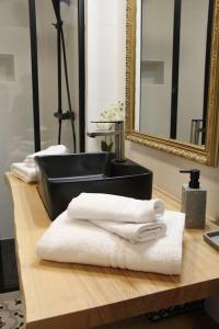 ein Badezimmer mit einem Waschbecken und Handtüchern auf der Theke in der Unterkunft Chez Franck et Gisele in LʼIsle-sur-la-Sorgue