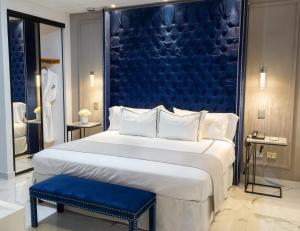 a bedroom with a large bed with a blue headboard at Hotel Posada San Antonio in Reynosa