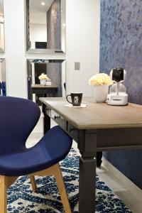 Elle comprend un bureau avec une chaise bleue et un téléphone. dans l'établissement Hotel Posada San Antonio, à Reynosa