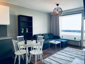 uma sala de estar com um sofá, uma mesa e cadeiras em Tapiola Center Apartment em Espoo