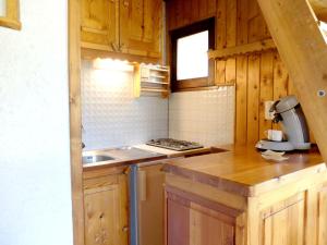 a kitchen with wooden cabinets and a stove top oven at Studio Tignes, 1 pièce, 4 personnes - FR-1-502-353 in Tignes