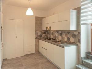 a kitchen with white cabinets and a sink at Casa Rubino Holiday Home - 50mt dal centro in Troia