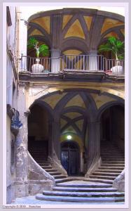 ナポリにあるcasa italiaの階段付きの建物、植物のあるバルコニー