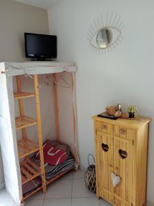 Pendé的住宿－La salicorne，一间房间,配有书桌和架子上的电视