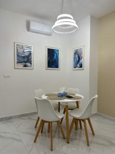 uma sala de jantar com mesa, cadeiras e pinturas em Boutique Luxury Residence em Budapeste