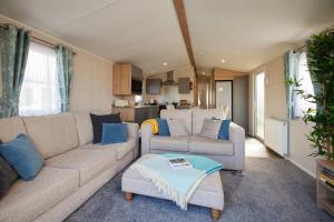 ein Wohnzimmer mit einem Sofa und einem Tisch in der Unterkunft Nirvana Coastal Retreat Holiday Home in Cayton