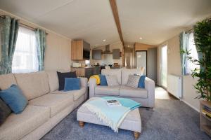 una sala de estar con un sofá y una mesa en Nirvana Coastal Retreat Holiday Home, en Cayton