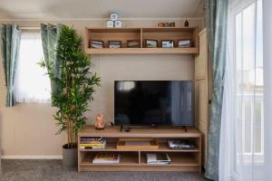 ein Wohnzimmer mit einem Flachbild-TV auf einem Entertainment-Center in der Unterkunft Nirvana Coastal Retreat Holiday Home in Cayton