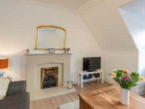a living room with a fireplace and a mirror at Goose Green View in Gullane