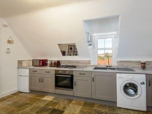 a kitchen with a sink and a washing machine at Goose Green View in Gullane