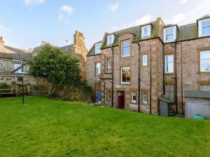 an empty yard in front of a large brick building at Goose Green View in Gullane