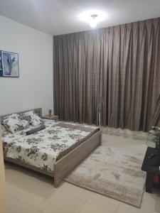 um quarto com uma cama e uma grande janela em Tiamooz Room in shared Apartment em Ajman