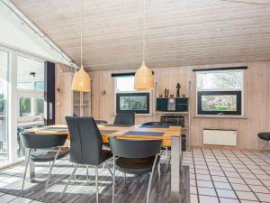 een eetkamer met een houten tafel en stoelen bij 8 person holiday home in Juelsminde in Sønderby