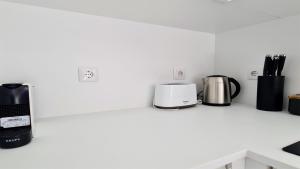 a kitchen counter with several appliances on a shelf at Marina Retreat - CleverDetails, for 2 adults and 2 children, Jacuzzi, near the Marina and the beach in Vilamoura