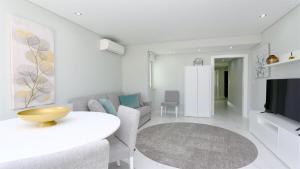 a white living room with a table and a couch at Marina Retreat - CleverDetails, for 2 adults and 2 children, Jacuzzi, near the Marina and the beach in Vilamoura +35 photos
