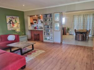 Una sala de estar con un sofá rojo y una mesa. en Alimandi Nursery Cottage, en Ciudad del Cabo