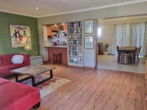 a living room with a red couch and a table at Alimandi Nursery Cottage in Cape Town
