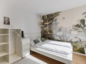 a bedroom with a white bed and a painting on the wall at Humboldt41 in Nuremberg