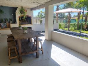 comedor con mesa de madera y sombrilla en Alimandi Nursery Cottage, en Ciudad del Cabo