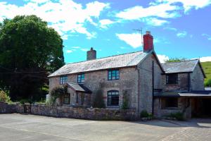 an old stone house sitting in a parking lot at Cynynion Uchaf - Countryside Farmhouse with Views in Oswestry