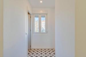 a white room with a window and a tile floor at Design Setubal in Setúbal +7 photos