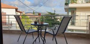 un tavolo e 2 sedie sul balcone di AYRA ROOMS ALIVERI a Aliveri