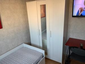 a small bedroom with a bed and a cabinet at Jolie chambre Nenuphar dans belle maison in Vaulx-en-Velin +6 photos