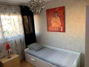 a bedroom with a bed and a painting on the wall at Jolie chambre Nenuphar dans belle maison in Vaulx-en-Velin