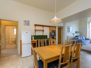 a kitchen and dining room with a table and a refrigerator at TenSea in North Berwick